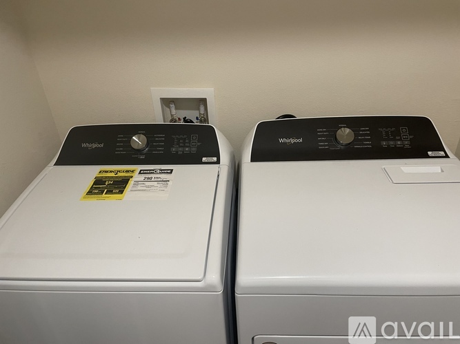 Two Whirlpool washing machines are side by side.