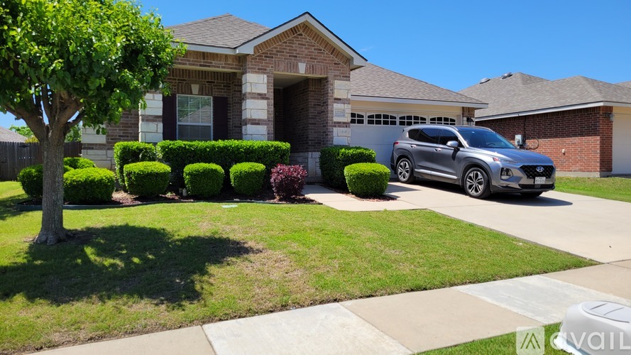 A house with a tree and a car parked in front.