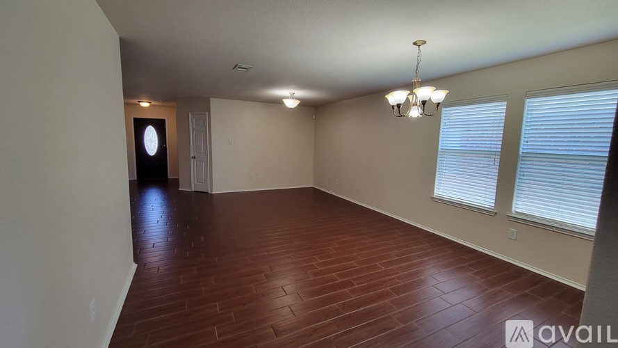 A room with wooden flooring and a chandelier.