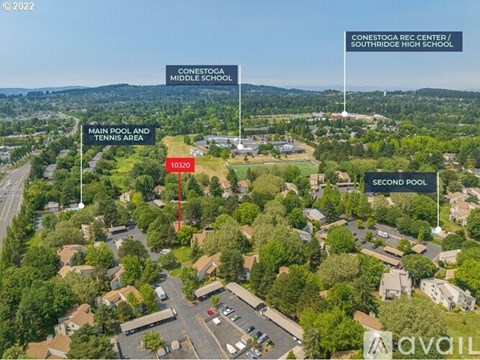 An aerial view of a school with a main pool and tennis area and a second pool.