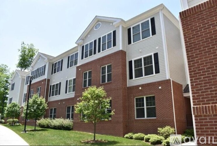 A multi-story building with a mix of brick and siding exterior.