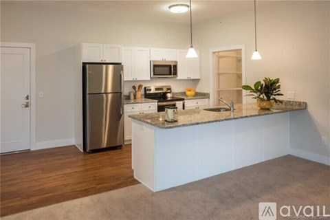 A kitchen with white cabinets and a stainless steel refrigerator.