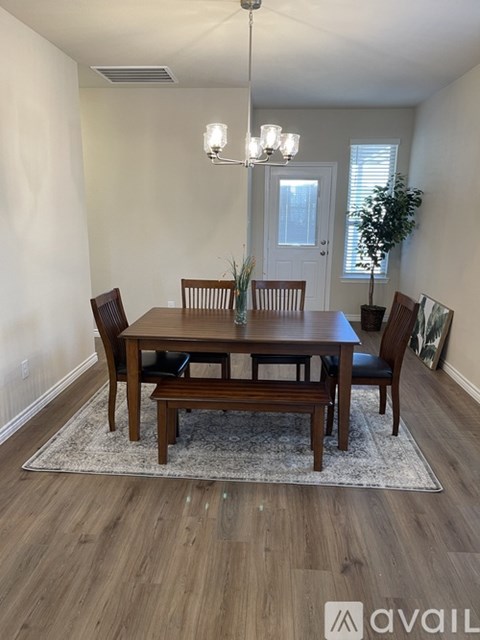 A dining room with a wooden table and chairs.
