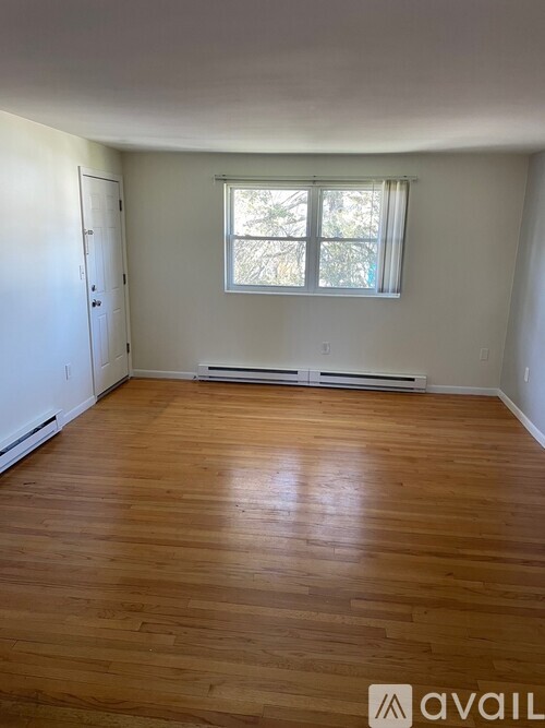 A room with wooden flooring and a window.