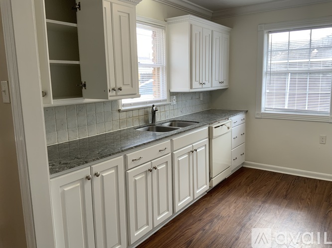 A kitchen with white cabinets and a granite countertop.