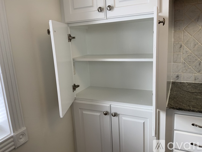 A white cabinet with an open door is in the foreground.