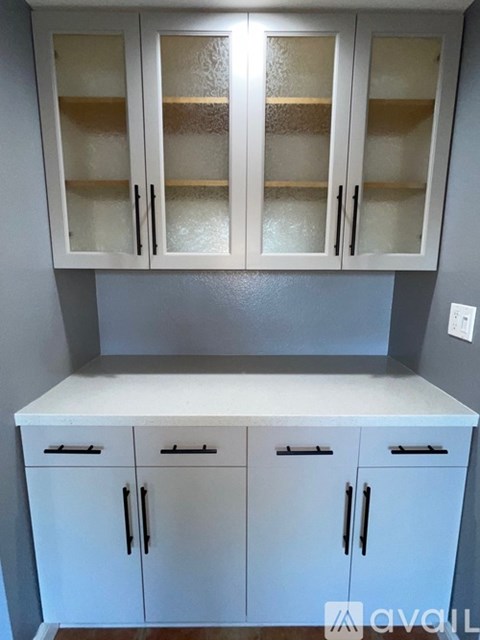 A kitchen with white cabinets and a counter.