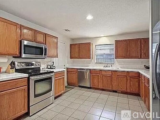A kitchen with wooden cabinets and a white countertop.