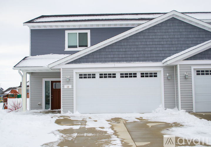 A house with a grey roof and a brown garage door.