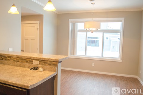 A kitchen with a granite countertop and a window with a view of a building outside.