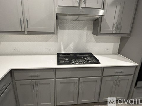 A kitchen with a stove top oven and cabinets.
