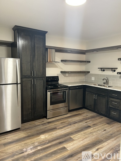 A kitchen with a refrigerator, oven, and sink.