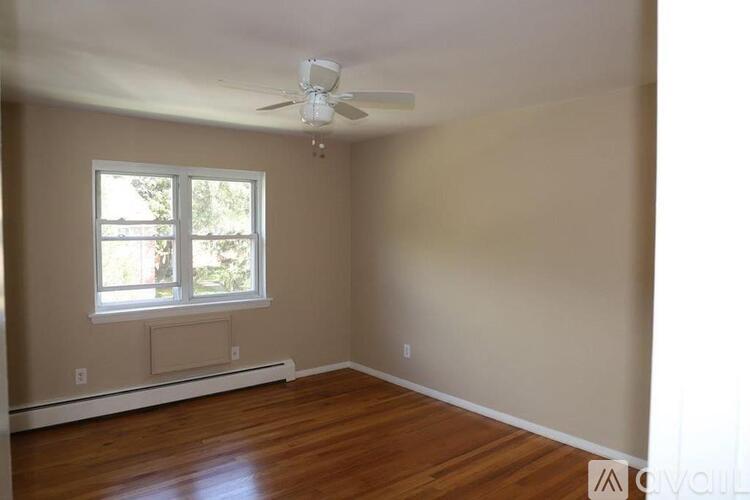 A room with a window and a ceiling fan.