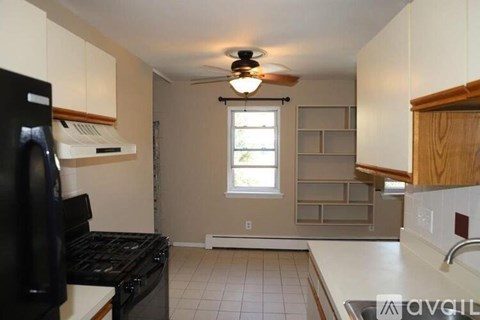 A kitchen with a black fridge and a window.