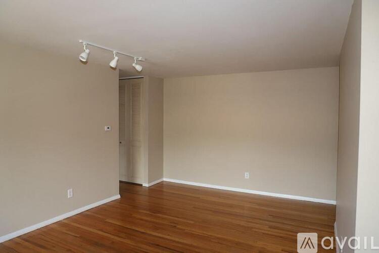 A room with wooden floors and a doorway leading to another room.