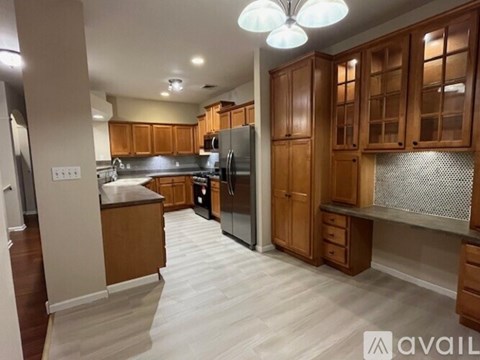 A kitchen with wooden cabinets and a black refrigerator.