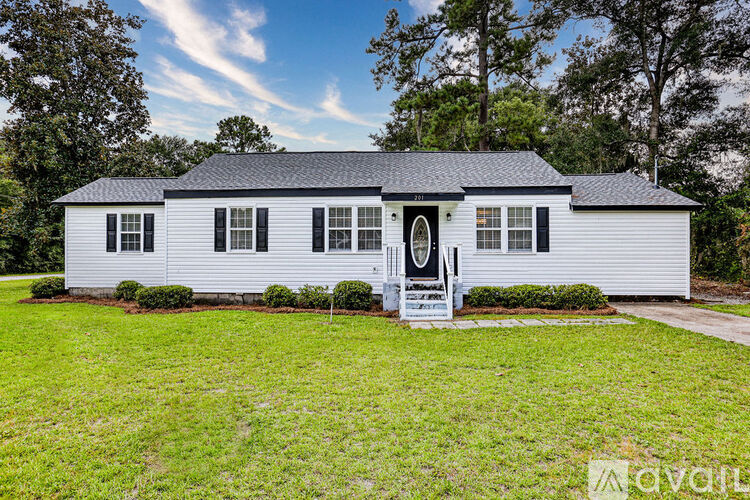 A white house with a black roof and a front porch.