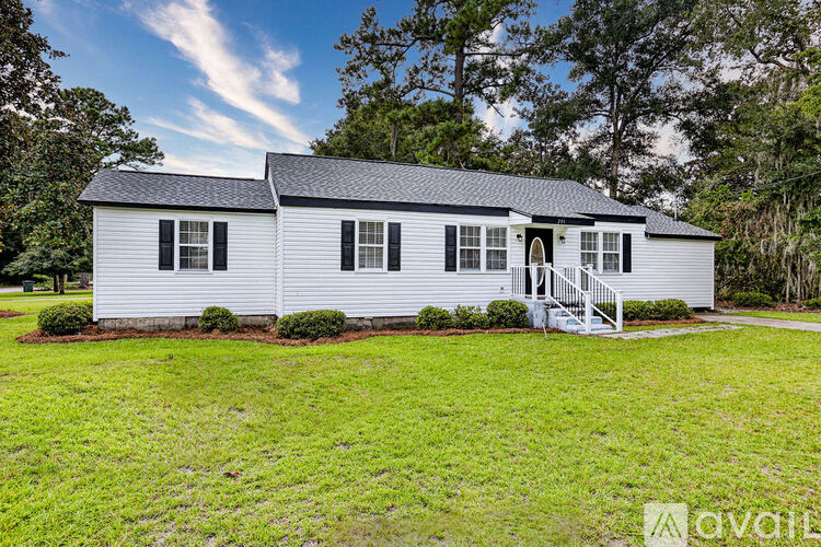 A white house with a black roof and a porch.