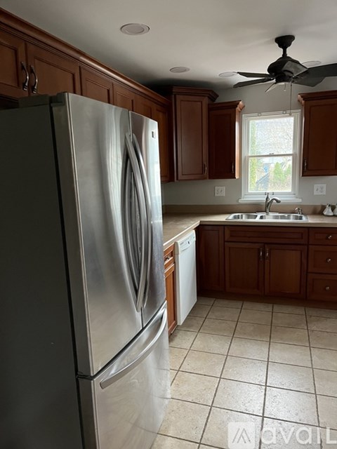 A kitchen with a stainless steel refrigerator and a fan on the ceiling.