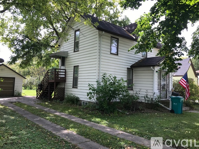 A house with a flag on the front porch is for sale.