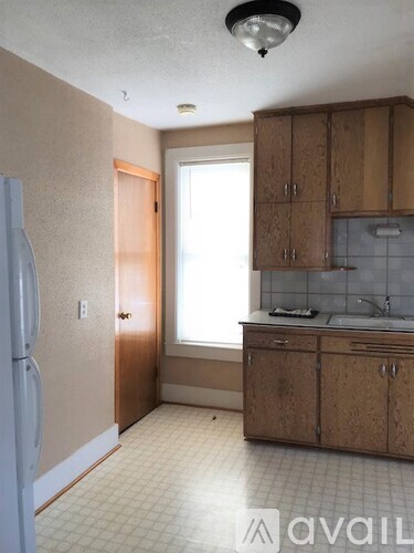 A kitchen with wooden cabinets and a white fridge.