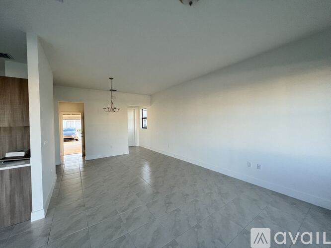 A spacious room with a chandelier and a large window.