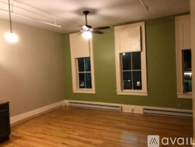 A room with wooden floors and a ceiling fan.