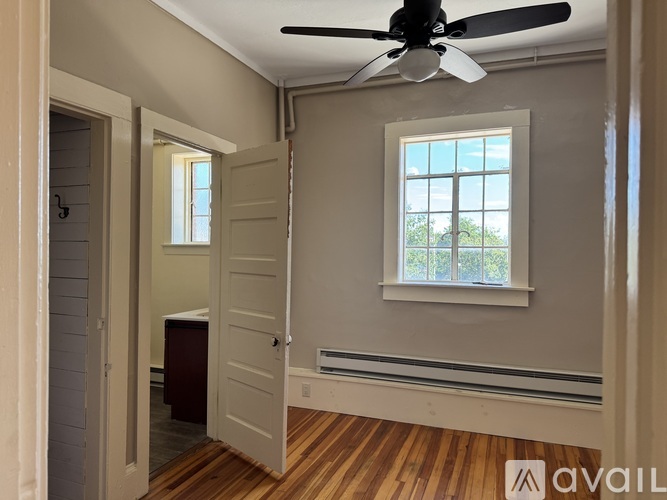 A room with a ceiling fan and a window.