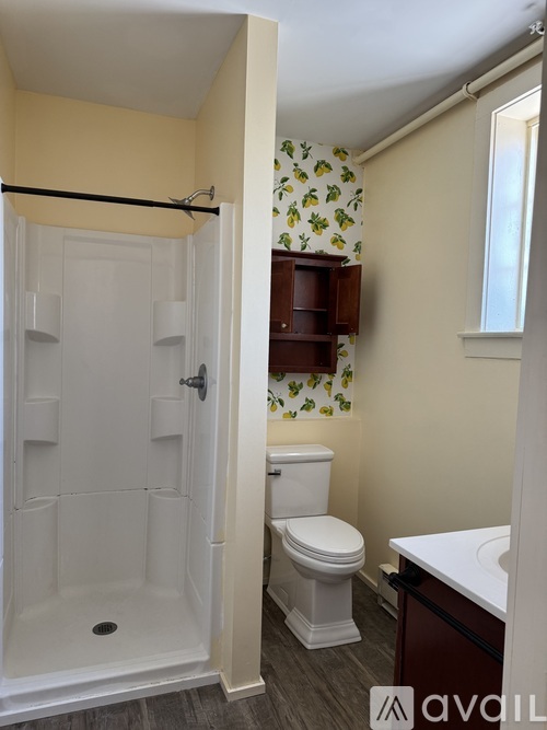 A bathroom with a toilet, sink, and shower.