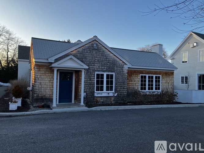 A house with a blue door and windows is available for sale.