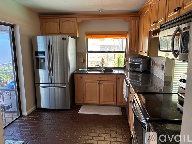 A kitchen with a refrigerator, oven, and microwave.