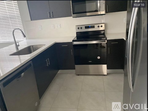 A kitchen with black cabinets and stainless steel appliances.