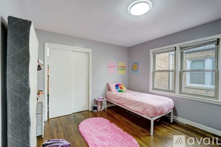 A bedroom with a pink bed and a pink rug.