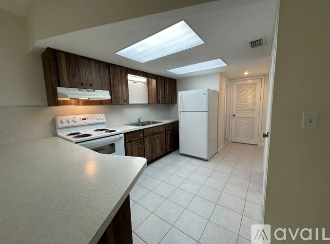 A kitchen with a white countertop and a white refrigerator.