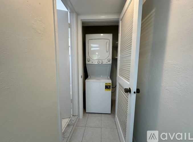 A white tankless water heater in a narrow hallway.