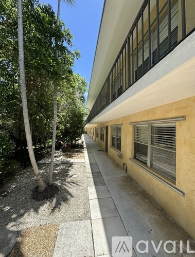 A long building with a tree in front of it.