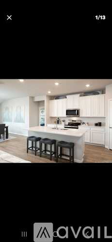 A modern kitchen with white cabinets and a central island.