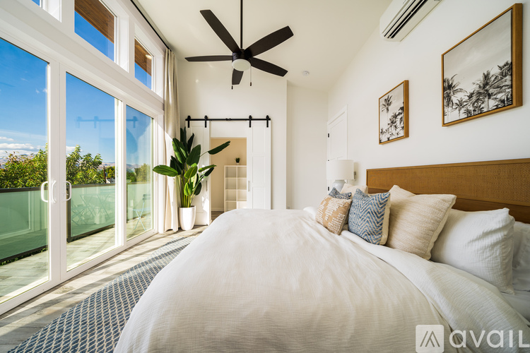 A bedroom with a large bed and a ceiling fan.