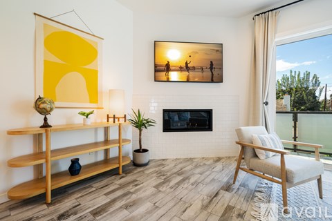 A living room with a fireplace, a chair, and a painting on the wall.
