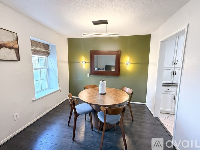 A dining room with a wooden table and chairs.
