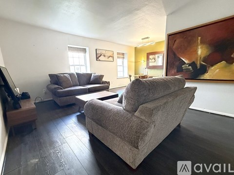 A living room with a grey couch and a brown armchair.