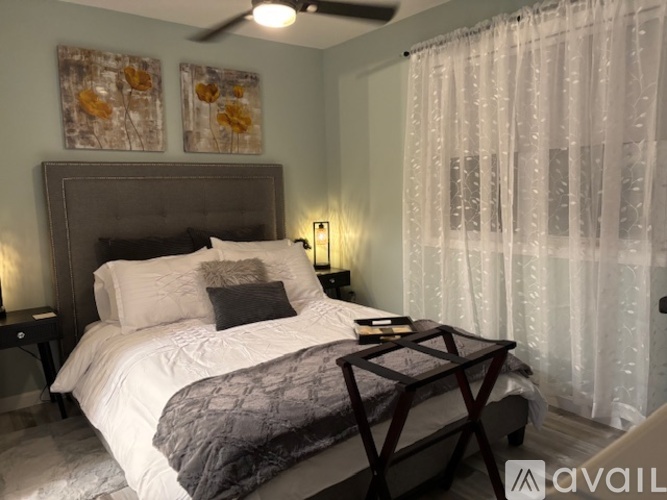 A bedroom with a large bed and a ceiling fan.