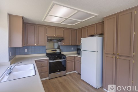 A kitchen with brown cabinets and a white refrigerator.