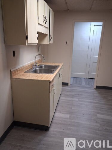 A kitchen with a sink and wooden countertop.
