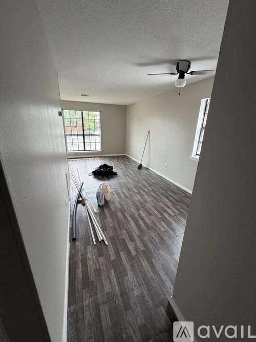 A room with a ceiling fan and a window with blinds.