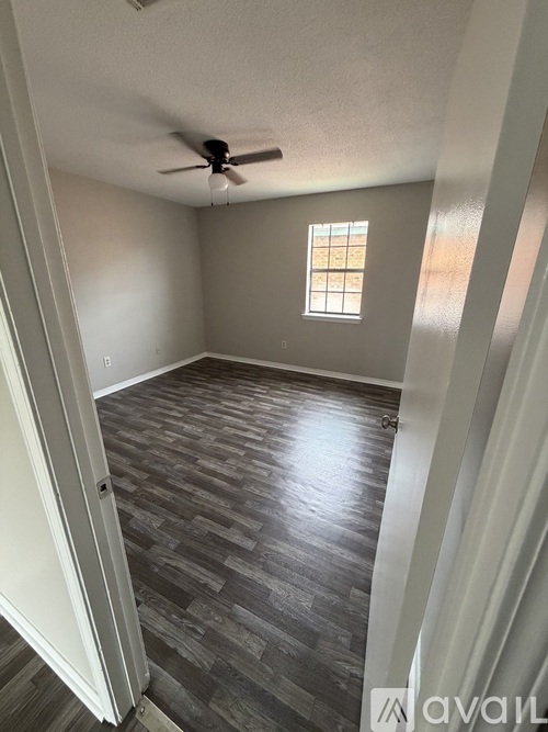 A room with a ceiling fan and a window.