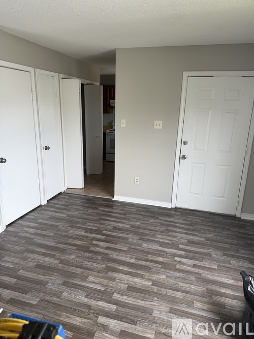 A hallway with a carpeted floor and white doors.