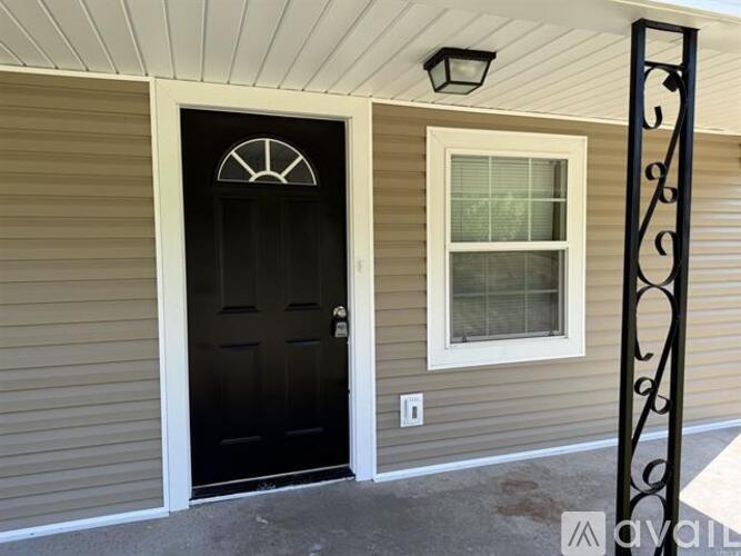 A black door with a white window to the right.