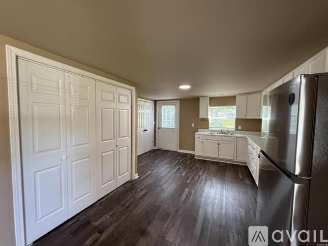 A kitchen with white cabinets and a refrigerator.