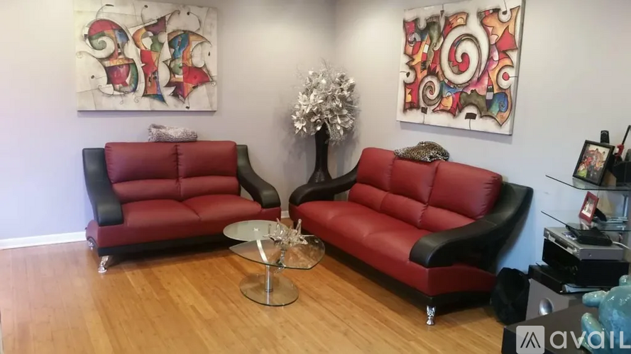 A living room with two red leather sofas and a glass coffee table.